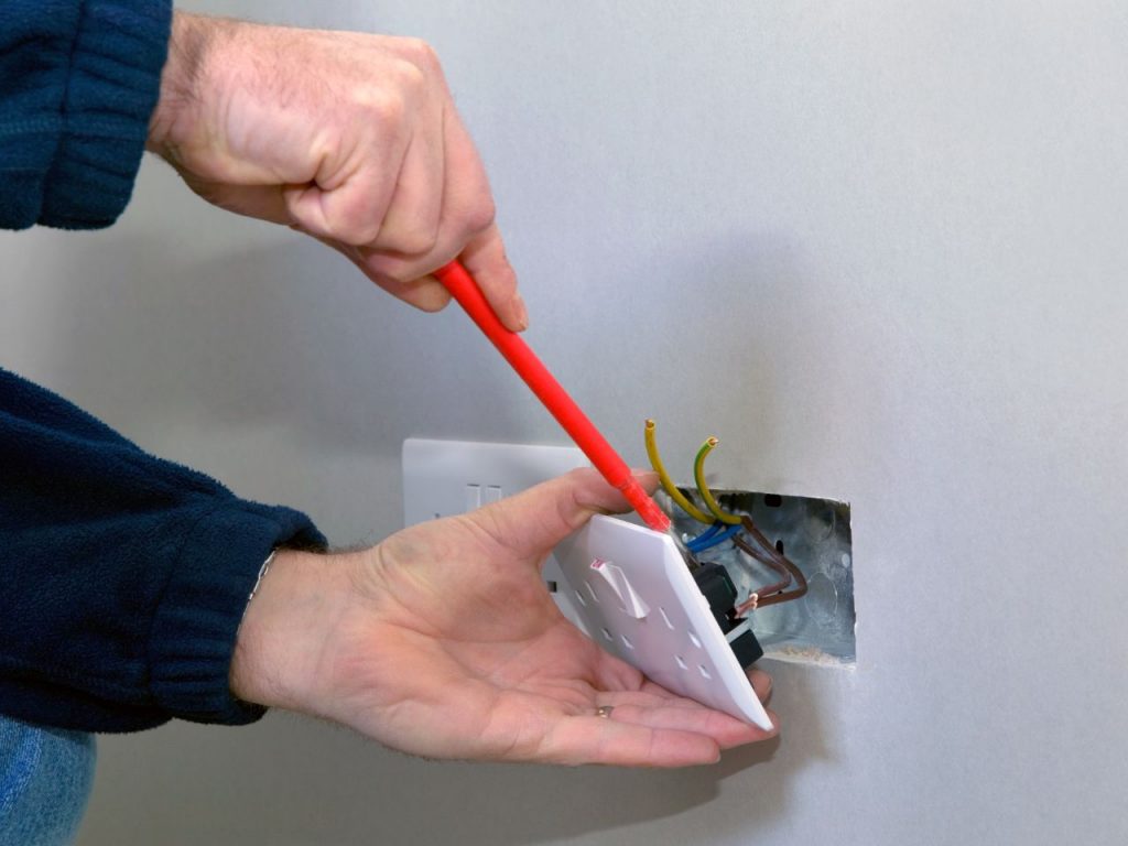 Electrician installing plug socket